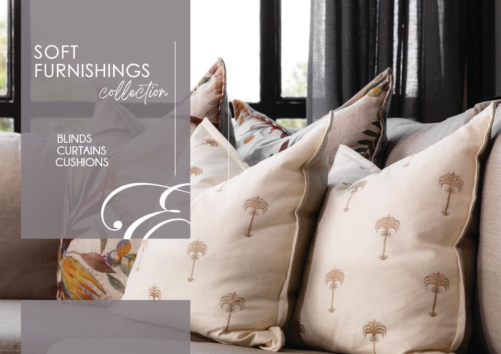 Decorative cushions in layered neutral and patterned fabrics on a sofa.