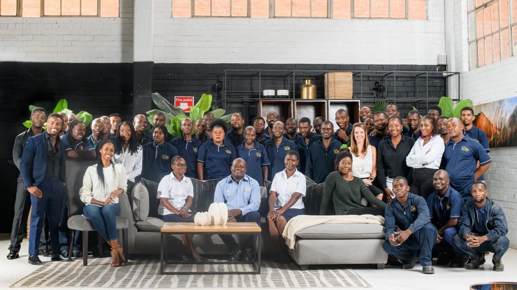 Elite Interiors team gathered in the showroom around bespoke seating.